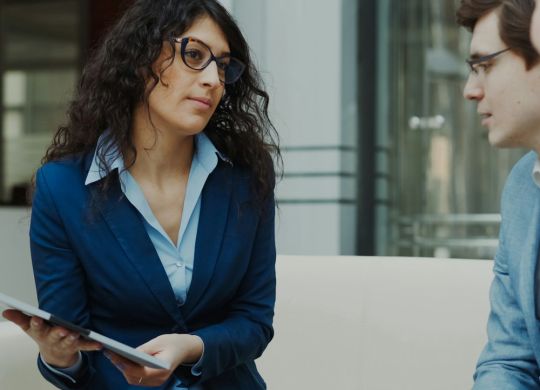 Three professionals in a business meeting discussion