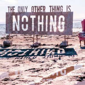 a pink chair sitting on top of a sandy beach