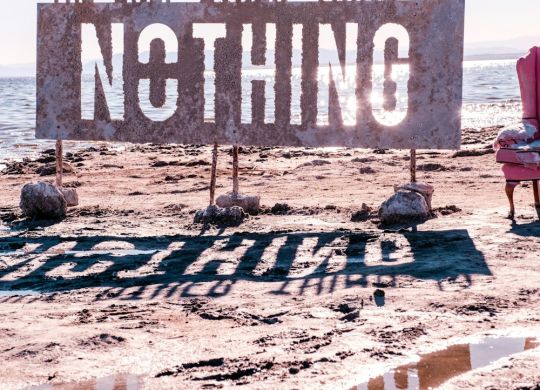 a pink chair sitting on top of a sandy beach
