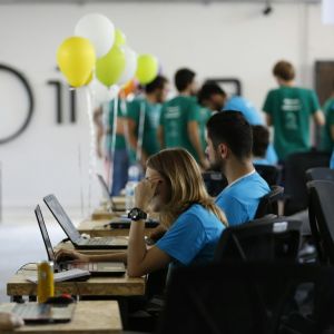 a group of people working on laptops in a room