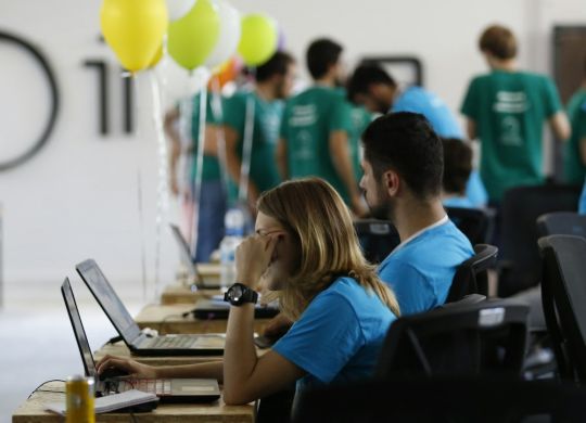 a group of people working on laptops in a room